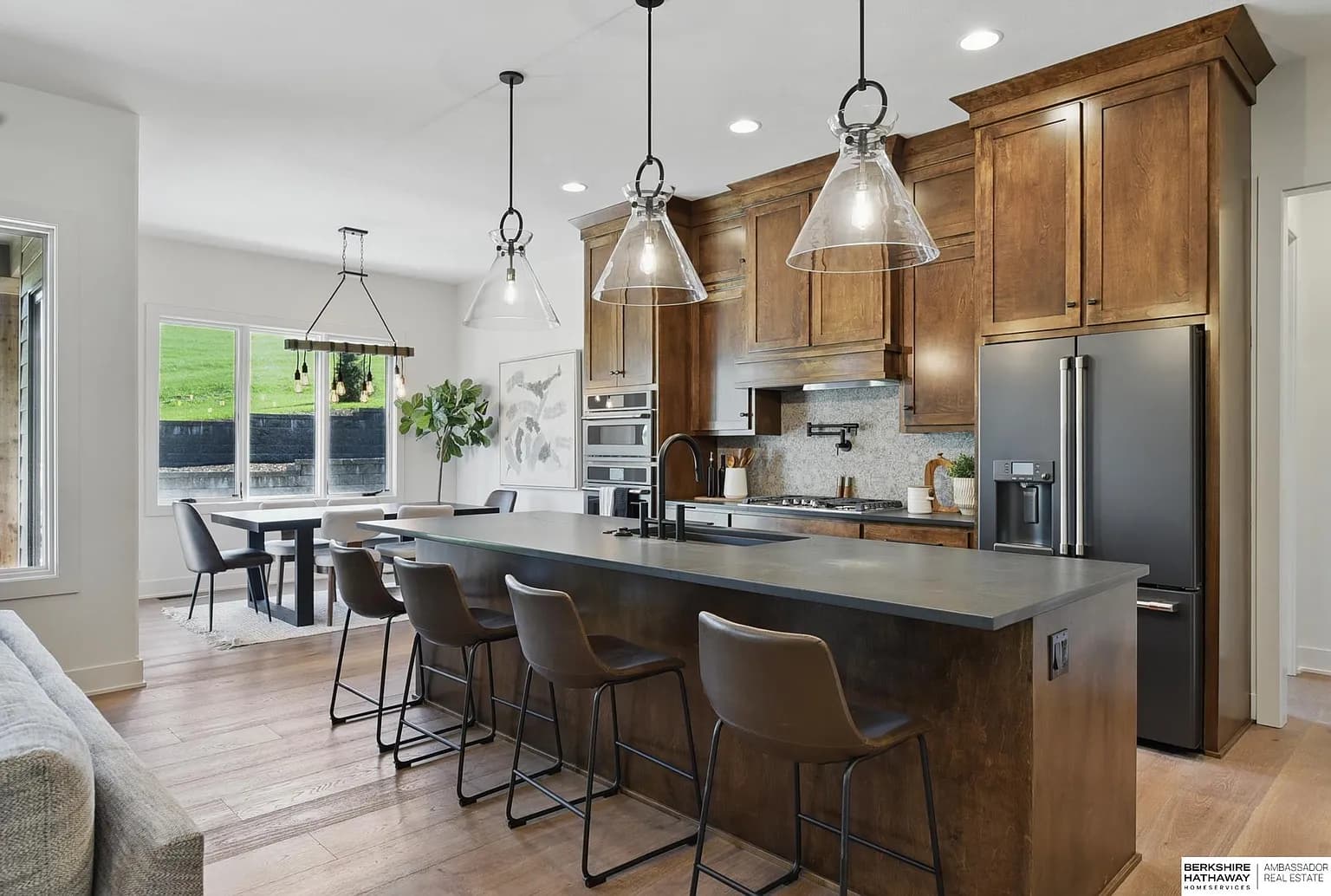 Custom kitchen with dark wood cabinetry, pendant lighting, and large island