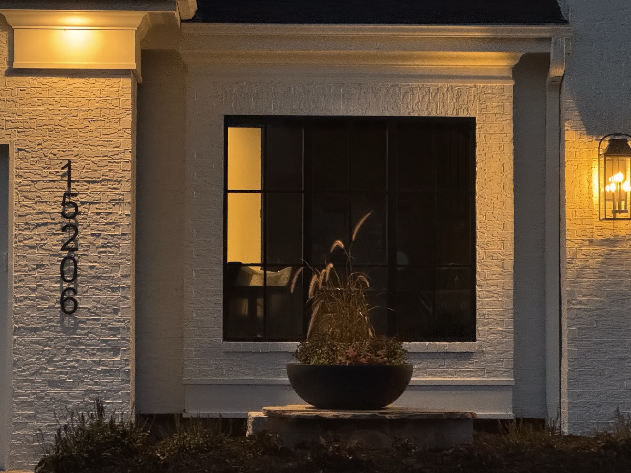 Custom home entry lit at dusk with stone facade